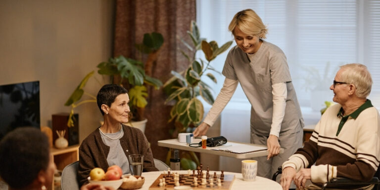 Female Nurse Serving Medications to Seniors at Assisted Living Facility