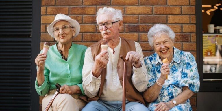 Elderly Friends Eating Ice Cream Outdoors at Independent Living Facility