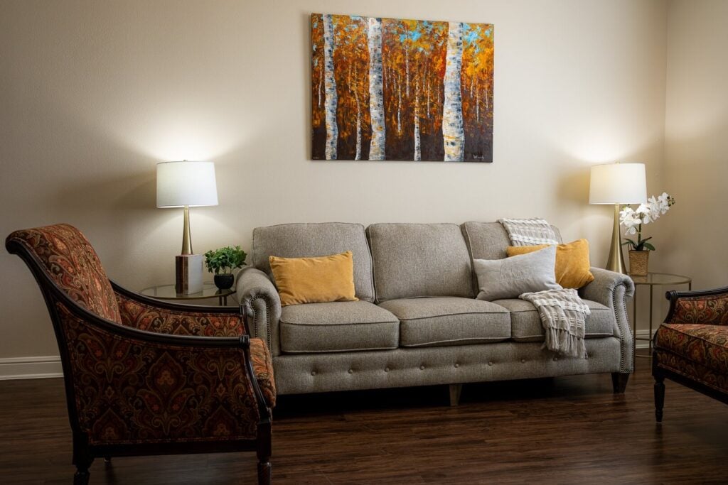 Warm Living Room with Sofa Seating at Assisted Living Facility
