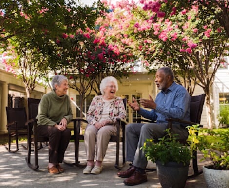 Elderly Friends Laughing in Garden at Assisted Living Facility Elderly Friends Laughing in Garden at Assisted Living Facility