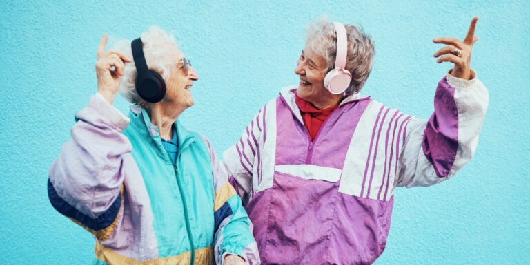 Elderly Women Dancing Together with Headphones at Memory Care Facility