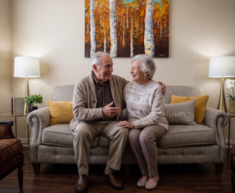 Smiling Elderly Couple Relaxing Together at Memory Care Community Smiling Elderly Couple Relaxing Together at Memory Care Community