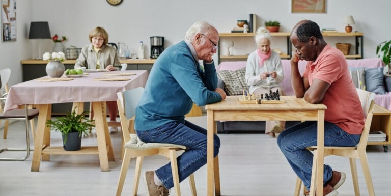 Elderly Men Playing Chess Together at Assisted Living Facility